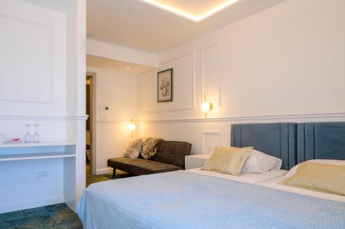 a hotel room with a bed and a couch at Hotel Krilo in Podstrana
