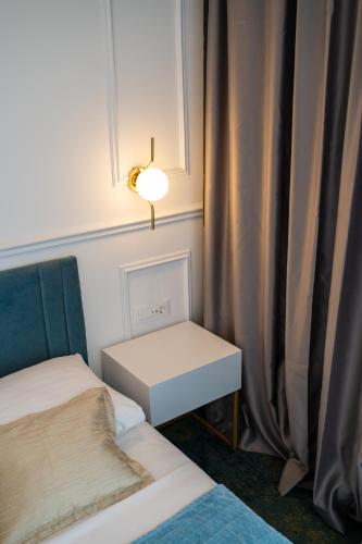 a room with two beds and a table and a lamp at Hotel Krilo in Podstrana