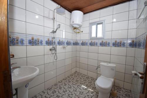 a bathroom with a toilet and a sink at J&B Home in Kribi