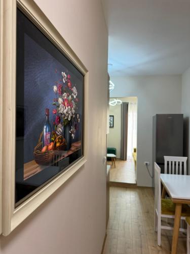 a painting of flowers and wine bottles on a wall at Haris Apartments Tirana in Tirana