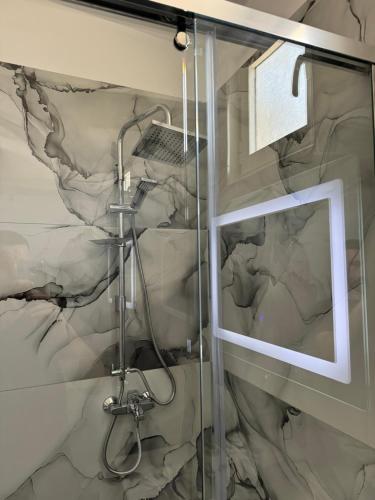 a bathroom with a shower with a picture on the wall at Haris Apartments Tirana in Tirana