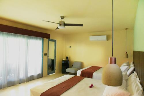 a bedroom with two beds and a ceiling fan at Hacienda Susulá in Susulá