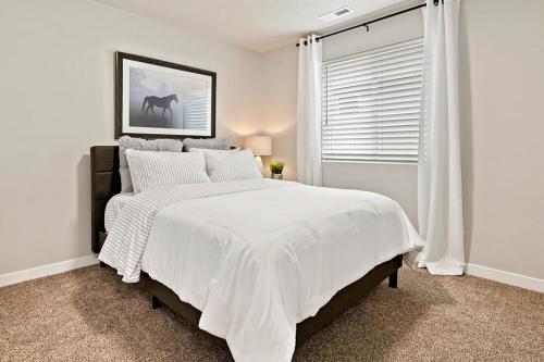 a white bedroom with a bed with white sheets and a window at Mineral Soak Rockers Fire Pit Game Room Fun in Meridian