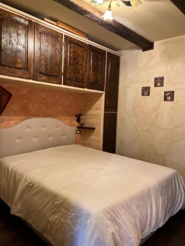 una camera con letto bianco e armadi in legno di Appartamento Il Tiglio a Roccaraso