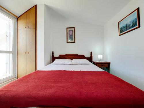 a bedroom with a large bed with a red blanket at Apartments Marina in Sveti Stefan