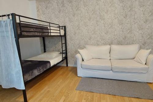 - un salon avec un canapé et des lits superposés dans l'établissement Disneyland 4 personnes Wifi Box Proche Gare Bus, à Esbly