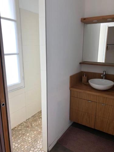 une salle de bain avec un lavabo et un miroir dans l'établissement Maison récente, à La Flotte