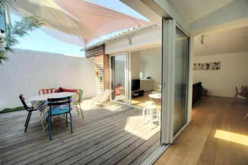 une chambre avec une table et des chaises sur une terrasse dans l'établissement Maison récente, à La Flotte