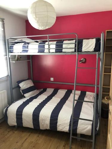 - une chambre avec 2 lits superposés et un mur rouge dans l'établissement Maison récente, à La Flotte