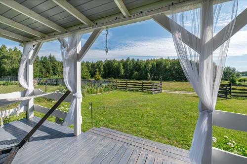 a view from the porch of a farmhouse with a marquee at Pod Żurawiem Urokliwy domek na Kaszubach in Michalin