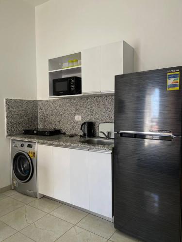 a kitchen with a refrigerator and a washing machine at Jasmine Resort & Aqua park in Sharm El Sheikh