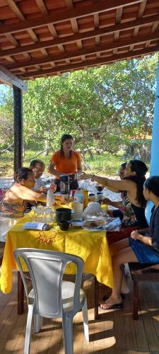 a group of people sitting at a table at Chalé Renilton Turismo in Santo Amaro