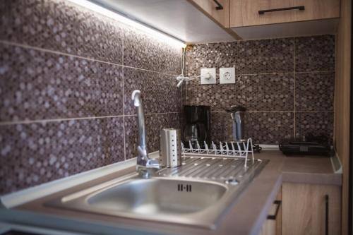 a kitchen sink with a faucet on top of it at Armonia House in Dhíkella