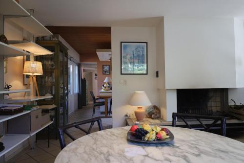 Cette chambre dispose d'une table avec une assiette de fruits. dans l'établissement Villa dans un cadre de verdure 110 m2 proche Golf et Lac, à Soorts-Hossegor