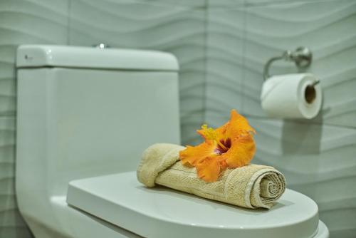a towel with a flower sitting on top of a toilet at Hare Nua Hotel Boutique in Hanga Roa