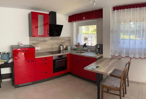 a kitchen with red cabinets and a wooden table at Zum Müntzer in Holtendorf