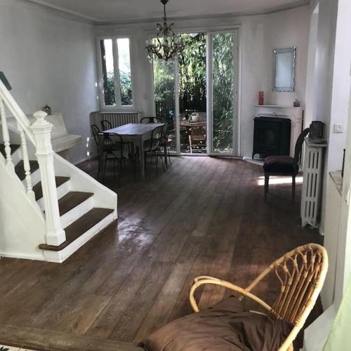 - un salon avec un escalier, une table et des chaises dans l'établissement Maison campagne à Paris , wifi, à Fontenay-sous-Bois