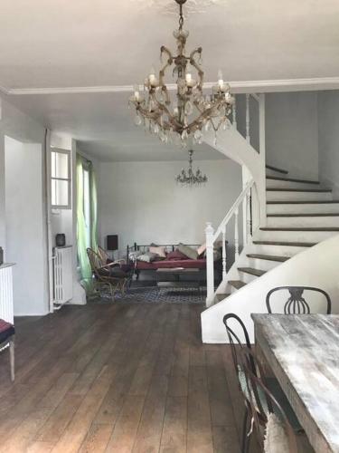 un salon avec un lustre et un escalier dans l'établissement Maison campagne à Paris , wifi, à Fontenay-sous-Bois
