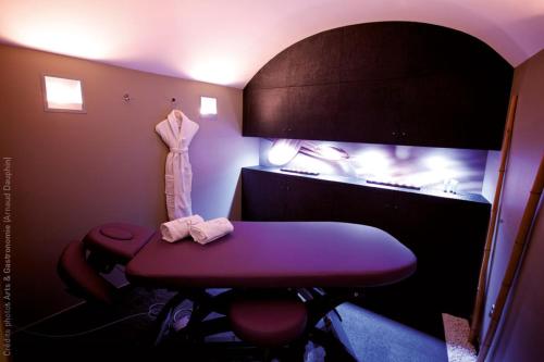 a room with a purple table and a fish tank at Hostellerie Du Chapeau Rouge in Dijon