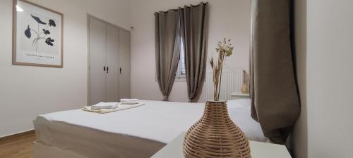 Cette chambre comprend un lit avec un vase sur une table. dans l'établissement Four Reasons, à Sparte