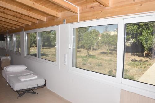 a room with three windows and a chair in it at Oceanides House in Lefkandi Chalkidas