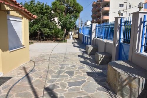 a cobblestone alley with blue fences and a building at Oceanides House in Lefkandi Chalkidas