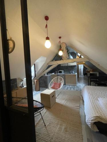 Cette chambre mansardée comprend un lit et une cuisine. dans l'établissement LE LOFT DU DOUBS, à Besançon