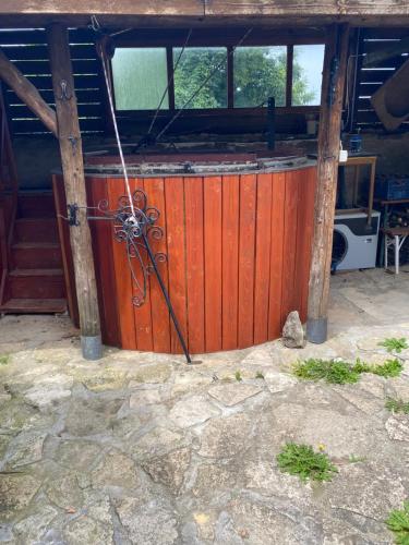 a wooden gate in a building with a door at Fűtetős Dombház in Üröm