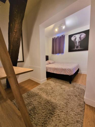 - une chambre avec un lit et un arbre sur le mur dans l'établissement Le Jeanne d'Arc, à Chinon