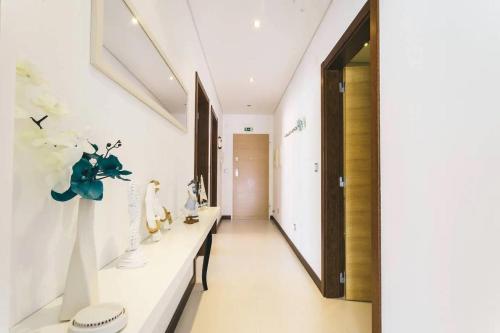 Un pasillo con paredes blancas y un largo mostrador con jarrones. en Lovely & New BEACH APARTMENT, en Atouguia da Baleia
