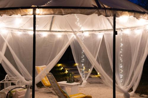 a tent with white curtains and lights on it at Casa Vacanze Villa Dan in Impalata