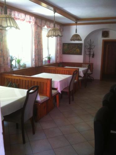 a dining room with tables and chairs and windows at Waldhof in Villach