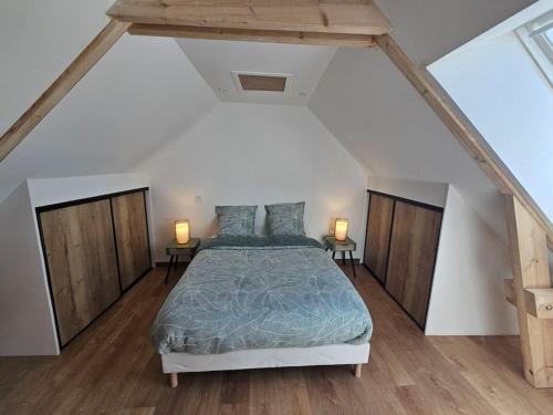 a bedroom with a bed and two lamps on tables at Appartement Cosy in Créances