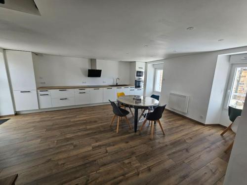 a kitchen with a table and chairs in a room at Appartement Cosy in Créances