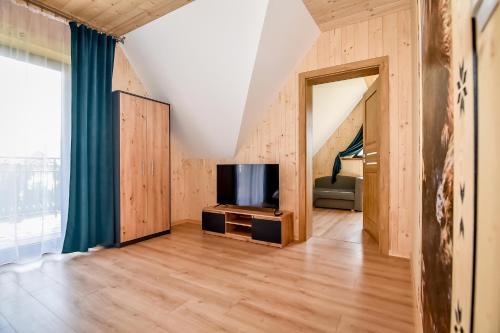 a living room with a flat screen tv next to a window at Magiczny Domek in Białka Tatrzanska