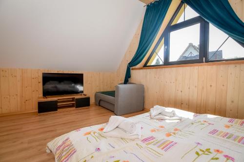 a bedroom with a bed and a large window at Magiczny Domek in Białka Tatrzanska