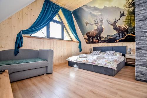 a bedroom with a bed and a painting of deer at Magiczny Domek in Białka Tatrzanska