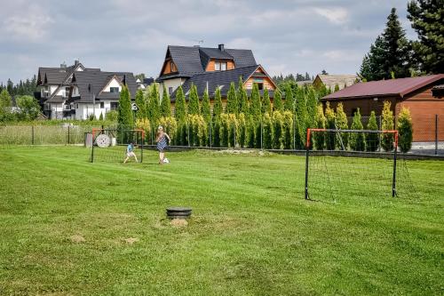 a woman and a child walking in a field at Magiczny Domek in Białka Tatrzanska