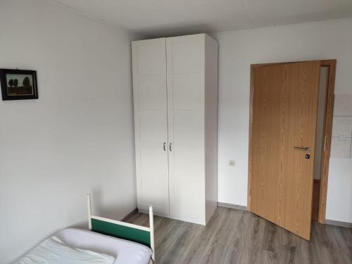 a bedroom with a bed and a wooden door at Gästehaus Rachinger in Pappenheim