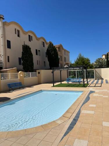 une piscine devant un immeuble dans l'établissement L'Albatros, à Gruissan