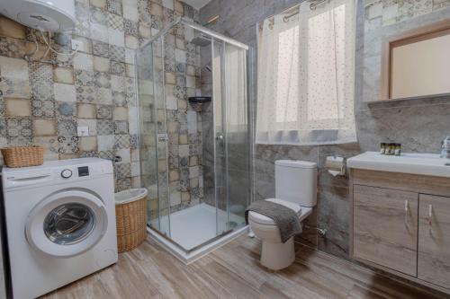 ein Badezimmer mit Waschmaschine und Dusche in der Unterkunft Brand new Apartament in Marsalforn in Żebbuġ