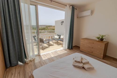 Schlafzimmer mit einem Bett und Blick auf einen Innenhof in der Unterkunft Brand new Apartament in Marsalforn in Żebbuġ