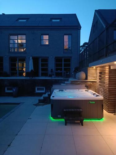 a patio with a hot tub in a yard at Appartement 5 personnes avec accès piscine et jacuzzi in Villers-la-Ville