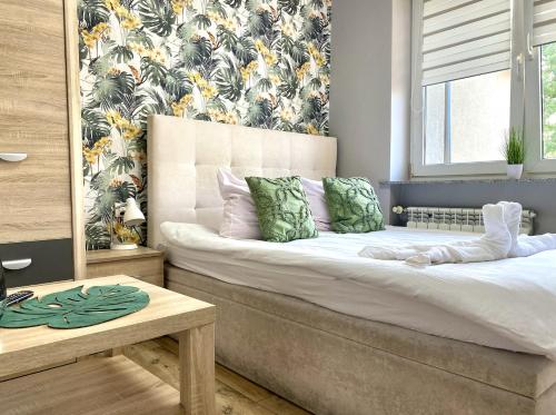 a bedroom with a bed and a window with a flowery wallpaper at Doba Rent POKOJE CENTRUM PAŁACOWA in Białystok