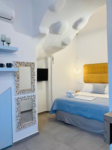 a bedroom with a bed and a mirror at Gerani Deluxe Houses in Astypalaia Town