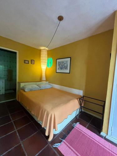 a bedroom with a bed in a room with yellow walls at Flat Muqui 91 in Teresópolis