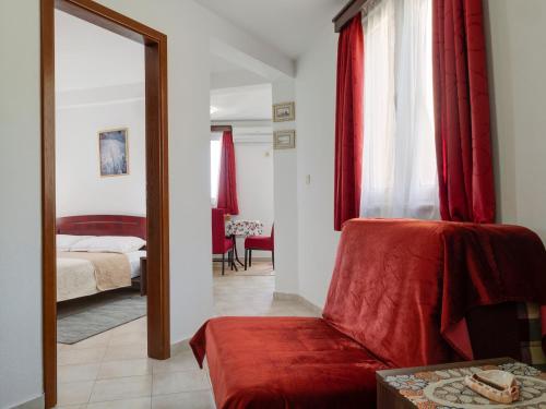 a bedroom with a bed and a mirror and a chair at Apartments Marina in Sveti Stefan
