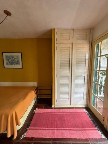 a bedroom with a bed and a window and a rug at Flat Muqui 91 in Teresópolis
