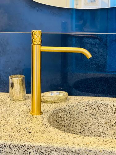 a yellow faucet on top of a counter at Gerani Deluxe Houses in Astypalaia Town