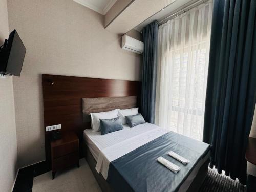 a bedroom with a bed with a large window at Arda Plaza Hotel in Tashkent